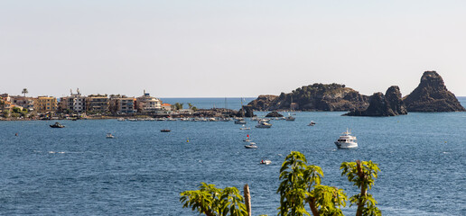 Islands of the Cyclops, off the coast of Aci Trezza, Sicily. Three tall, prominent sea stacks, which, according to local legend, were the great stones thrown at Odysseus in the epic poem The Odyssey.