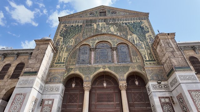 A majestic view of the Umayyad Mosque in Damascus, one of the oldest and most significant mosques in the world. The scene highlights its grand courtyard, intricate mosaics, and iconic Islamic architec