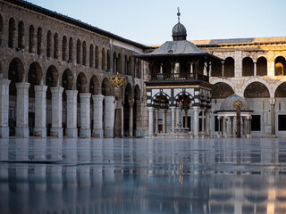 A majestic view of the Umayyad Mosque in Damascus, one of the oldest and most significant mosques in the world. The scene highlights its grand courtyard, intricate mosaics, and iconic Islamic architec