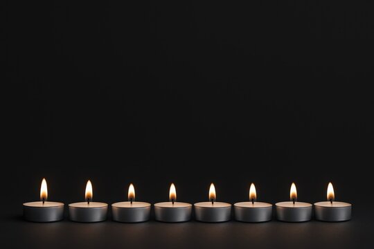 Row of Tealight Candles Burning Brightly Against a Dark Background, Perfect for Spiritual and Memorial Concepts