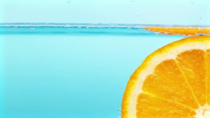 Juicy Orange Slice Dropped Into Refreshing Blue Water Video