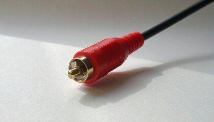 Three RCA connectors—red, white, and yellow—lying on white surface, attached to black cables. Symbolizing analog audio/video transmission, retro tech, and tactile connection systems.