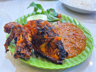 Savor delicious Ayam Bakar Indonesian grilled chicken with vibrant sambal and fresh greens
