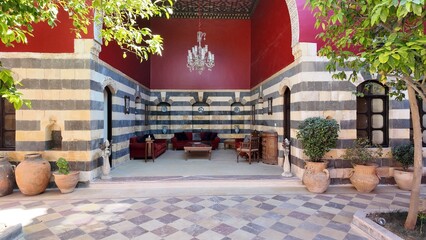 A charming view of the Talisman Hotel in Old Damascus, located in the historic Jewish Quarter. The traditional Arabic house features soft pink walls, classic courtyard architecture, and authentic Leva