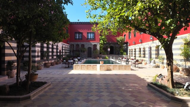 A charming view of the Talisman Hotel in Old Damascus, located in the historic Jewish Quarter. The traditional Arabic house features soft pink walls, classic courtyard architecture, and authentic Leva