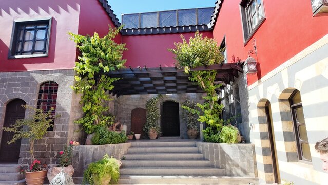 A charming view of the Talisman Hotel in Old Damascus, located in the historic Jewish Quarter. The traditional Arabic house features soft pink walls, classic courtyard architecture, and authentic Leva