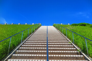 快晴の青空と緑の草が生い茂る堤体の歩道の風景11