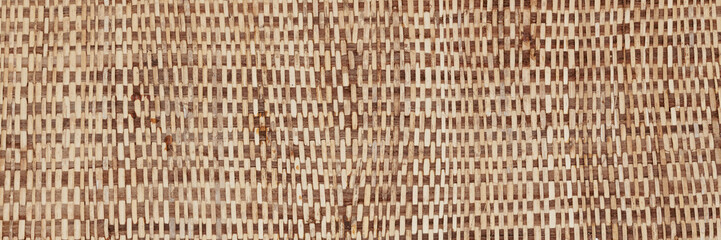 A close-up texture of a handmade bamboo weaving mat, showcasing its intricate handcrafted pattern, eco-friendly real material ideal for backgrounds, Asian decor, rustic themes, and sustainable design