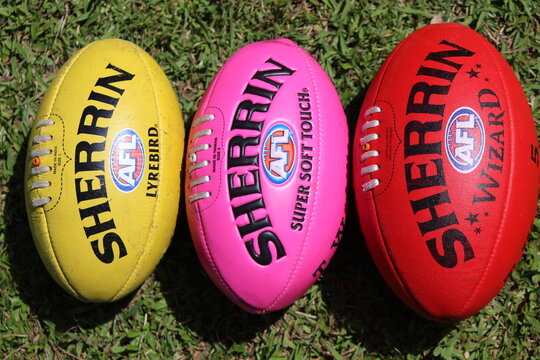 A yellow, pink and red Sherrin Australian rules football