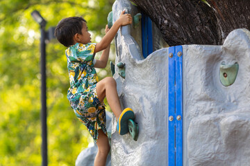 School boy enjoy climbing outdoor playground city park
