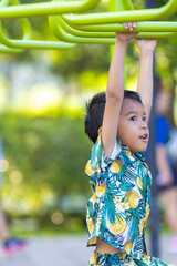 Fototapeta premium School boy enjoy climbing outdoor playground city park