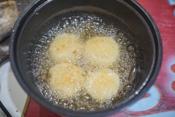 Traditional Indonesian snack combro being deep-fried in an electric fryer until golden and crispy.	