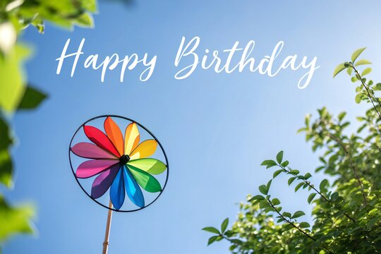 Colorido molinillo de viento contra un cielo azul brillante con el texto "Feliz Cumplea&ntilde;os".