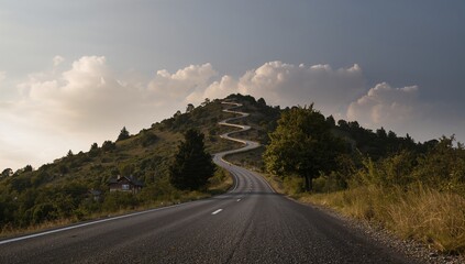The winding road appears treacherous as it climbs the mountain under a cloudy sky, erosion risk