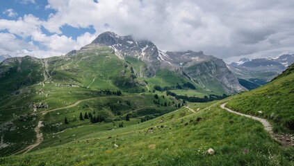 Lush green hills with patches of snow and rocky formations under a cloudy sky, inviting exploration of the serene landscape