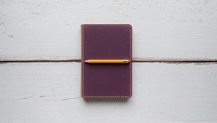 Purple notebook accompanied by a yellow pencil and eraser on a white wooden surface, ideal for study and organization