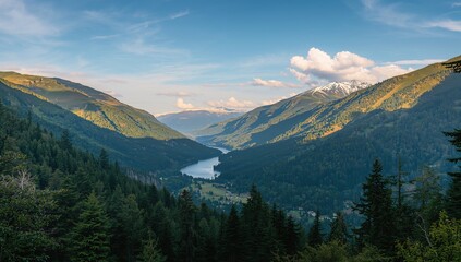 Fototapeta premium A scenic view of vibrant green mountains with snowy summits beneath a bright blue sky, emphasizing seasonal change