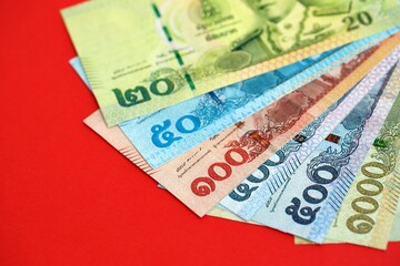 Obraz premium Thai baht money bills in big amount on red close up. Finance and banking concept