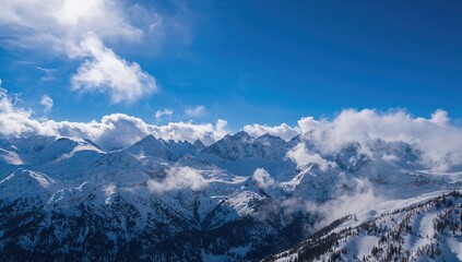 Vertical view of snow-laden mountains beneath a vibrant blue sky, seasonal change