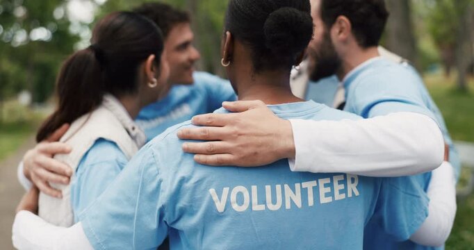 Volunteer, people outdoor and huddle with discussion for NGO support, outreach and nonprofit service. Back, team hug and talk in park for charity work, social responsibility or project collaboration.