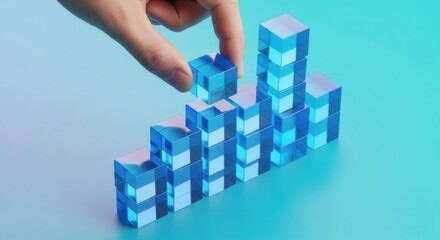 Hand placing a blue cube on top of a stack of transparent blocks in a creative arrangement during a playful activity
