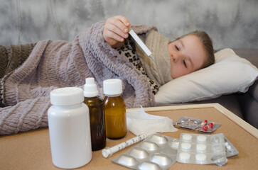 A little girl is lying in bed sick. The concept of illness, cold, acute respiratory viral infection