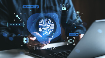 Biometric fingerprint authentication interface displayed above a person's hand using a laptop,...