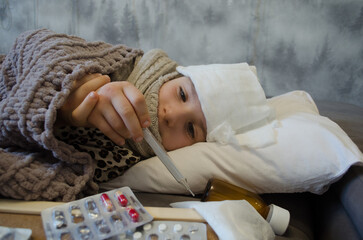 A little girl is lying in bed sick. The concept of illness, cold, acute respiratory viral infection
