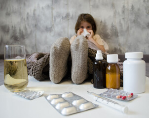 A little girl is lying in bed sick. The concept of illness, cold, acute respiratory viral infection