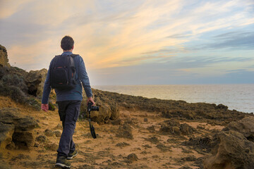 Photographer walking on a rocky coast