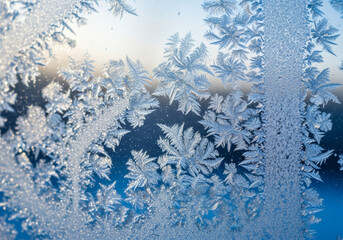 Delicate frost patterns on winter window at sunrise