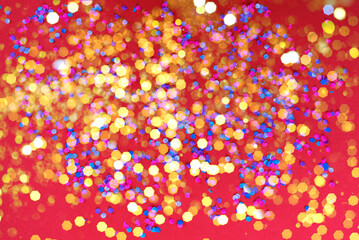 colorful bokeh lights on red background with glittering gold confetti and soft shimmer, out-of-focus sparkles