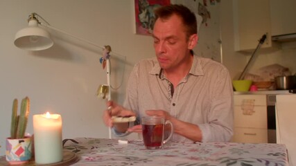 white man savoring dessert and tea at softly lit table, thoughtful facial expressions, spoonful tasting for food blog