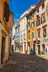 Narrow cobbled streets with colorful houses in the historic center of the coastal city of Piran, Slovenia.