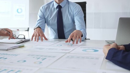 Business professionals analyzing financial charts and graphs during corporate meeting, focusing on data strategy, growth performance, and market planning - Powered by Adobe