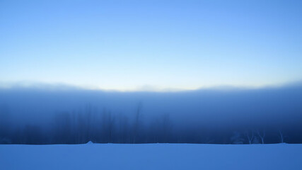 Winter horizon fading into misty blue fog