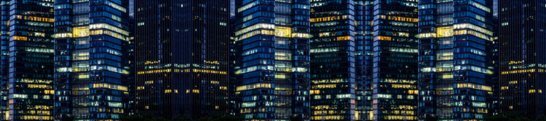 Multi-stories office building at night with worker working overtime. late night at office. lighting and working people within © Roberto Sorin