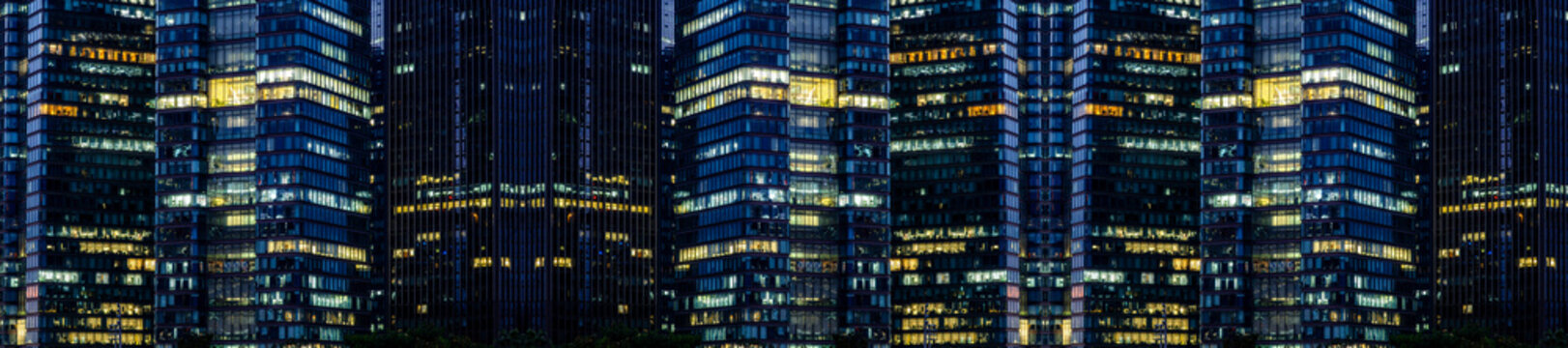 Multi-stories office building at night with worker working overtime. late night at office. lighting and working people within