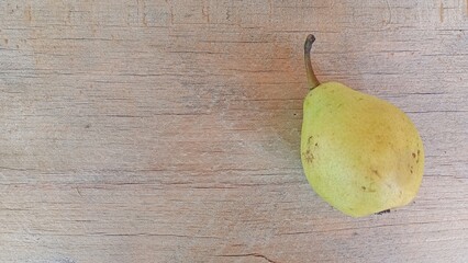 Ripe pear on an old wooden background, space for text