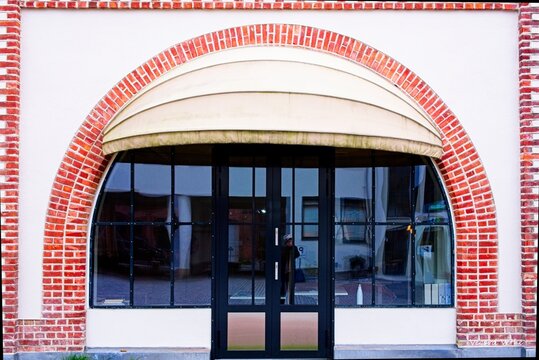 symmetrical red brick and glass doors, charming city storefront with neutral tones and classic design