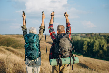 Mature partners hikers enjoy Nordic walking trekking at countryside