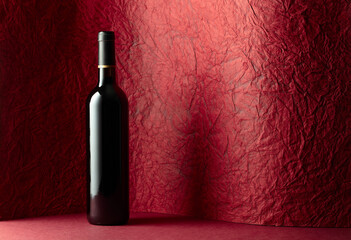 Bottle of red wine on a red background.