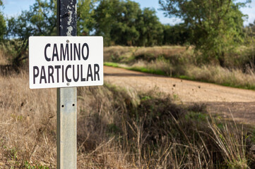Restricted Access Warning: Focus on the Sign and Shallow Depth of Field on the Road. 'Private Road'.