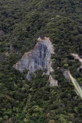 Naklejka premium Aerial view of big rock formation covered by trees.