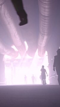 silhouette of many construction workers walking out from a large tunnel
