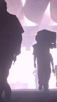 silhouette of many construction workers walking out from a large tunnel