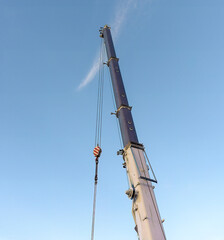 mobile tower crane stand in vertical position against a light blue sky background