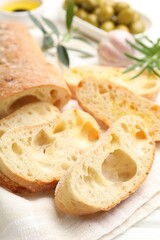 Fresh cut ciabatta on white wooden table, closeup