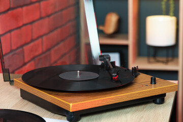 Modern turntable with vinyl record at home, closeup