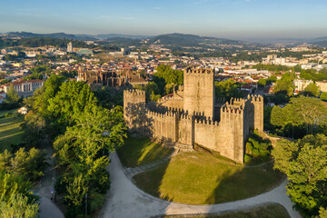 Fototapeta premium Aerial sunrise view of Guimaraes Castle, historic hilltop fortress in Portugal